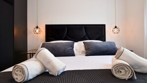 A neatly made bed with a black headboard, two bedside lamps, and rolled towels on the bed. - Apartment  by Interhome (Zadar/Bibinje)