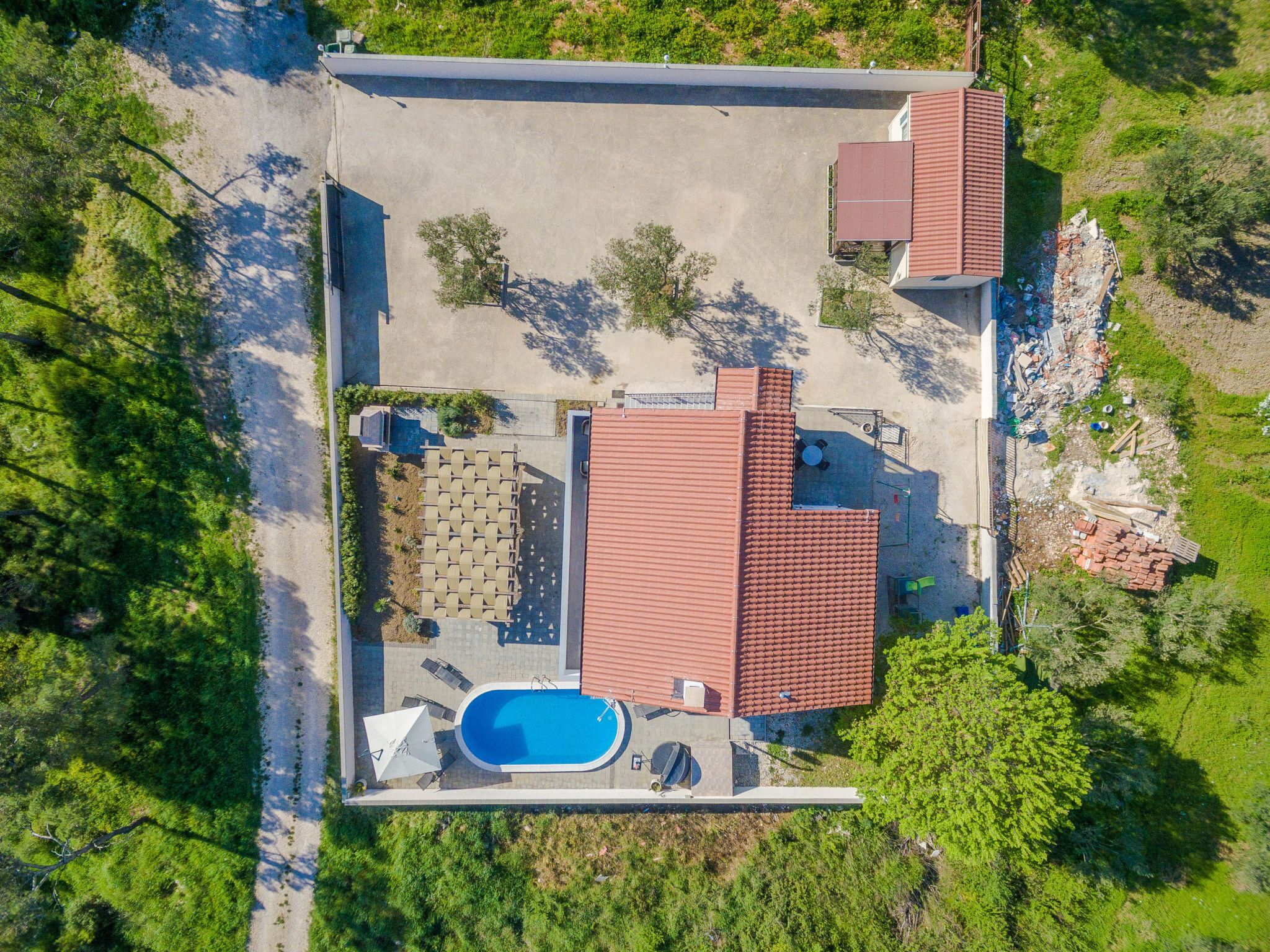 Um imóvel residencial com piscina, área de estar no pátio e um pequeno jardim.