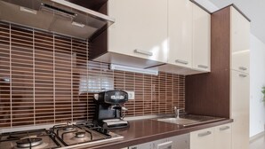 A modern kitchen with a gas stove, coffee maker, and a dishwasher. - Beautiful villa Horizon by Interhome (Crno)