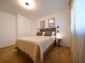 A bedroom with a bed, a bedside table with a lamp, and two framed pictures on the wall. - Villa Nostro Porto with pool by Interhome (Crno)