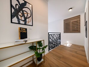 A modern interior with a white console table, a book titled 'TOM FORD' by VOGUE, a potted plant, and a black decorative partition. - Villa Nostro Porto with pool by Interhome (Crno)