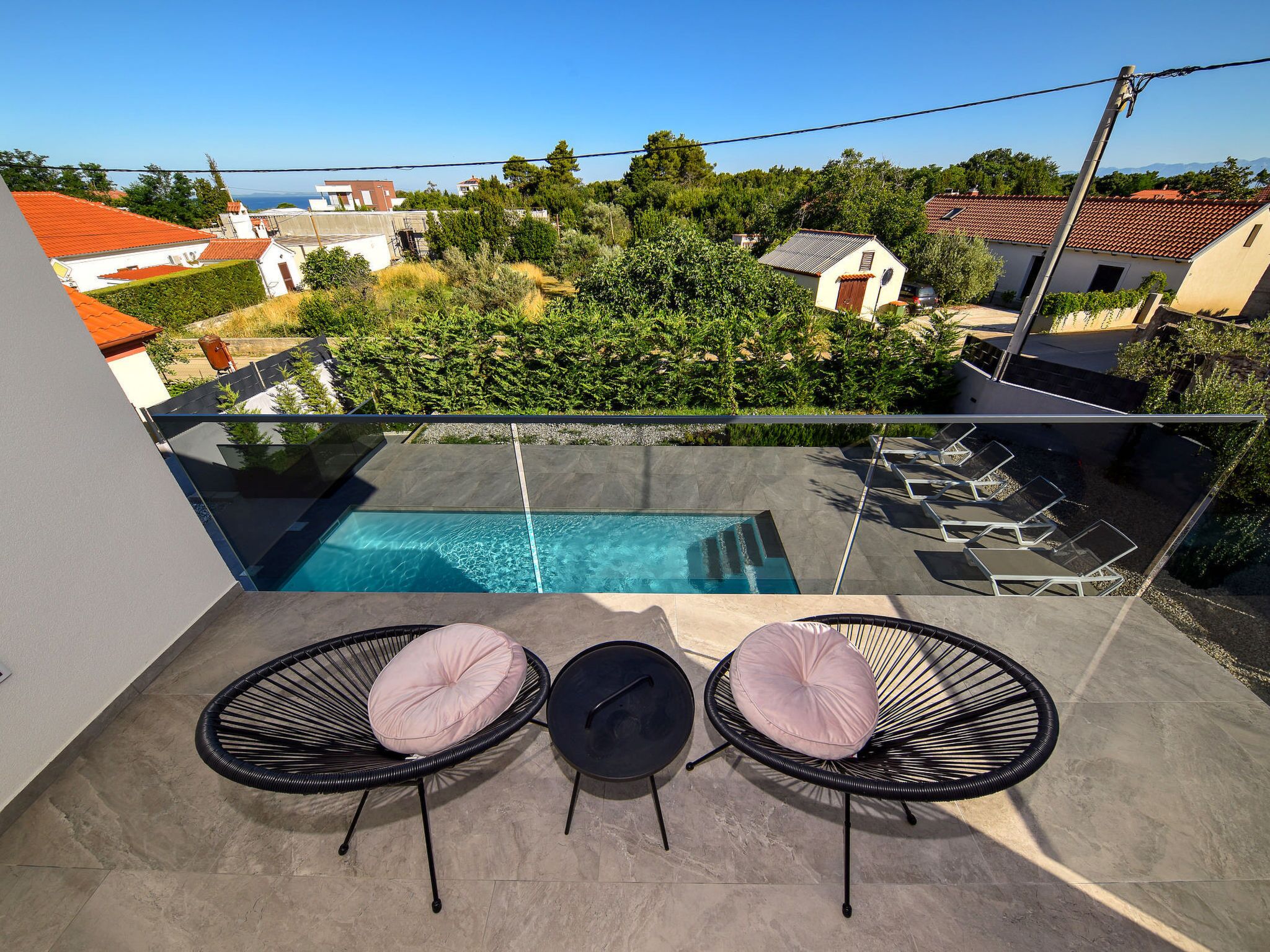 Een balkon met een zwembad, twee stoelen en een tafel.