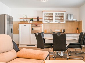 A modern kitchen with white cabinets, a built-in oven, and a dining area with a round table and four chairs. - Holiday Home Urbana with pool by Interhome (Crno)