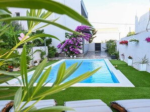 A swimming pool with a surrounding garden, a white building, and a clear sky. - Holiday Home Urbana with pool by Interhome (Crno)
