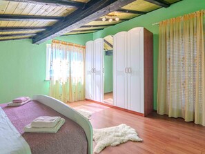 Quarto com cama, guarda-roupa e espelho.