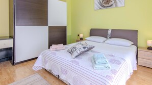 A bedroom with a bed, bedside tables, a nightstand, a wall-mounted artwork, and a wardrobe. - Villa Annamaria with large pool, Zadar by Interhome (Crno)