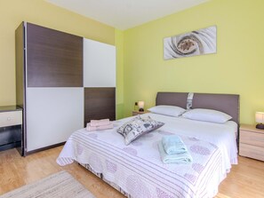 A bedroom with a bed, bedside tables, a nightstand, a wall-mounted artwork, and a wardrobe. - Villa Annamaria with large pool, Zadar by Interhome (Crno)