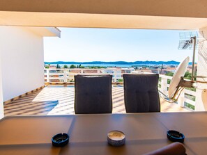 A balcony with two chairs, a table, and a satellite dish. - Villa Annamaria with large pool, Zadar by Interhome (Crno)