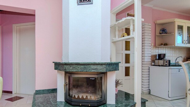A room with a fireplace, a kitchen area, and a wooden floor. - Villa Annamaria with large pool, Zadar by Interhome (Crno)