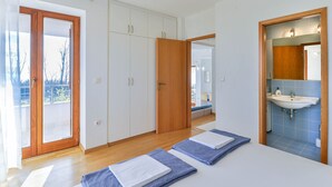 Makuuhuoneessa on suuri vaatekaappi, kylpyhuoneessa pesuallas ja huoneesta on näkymä ulos.