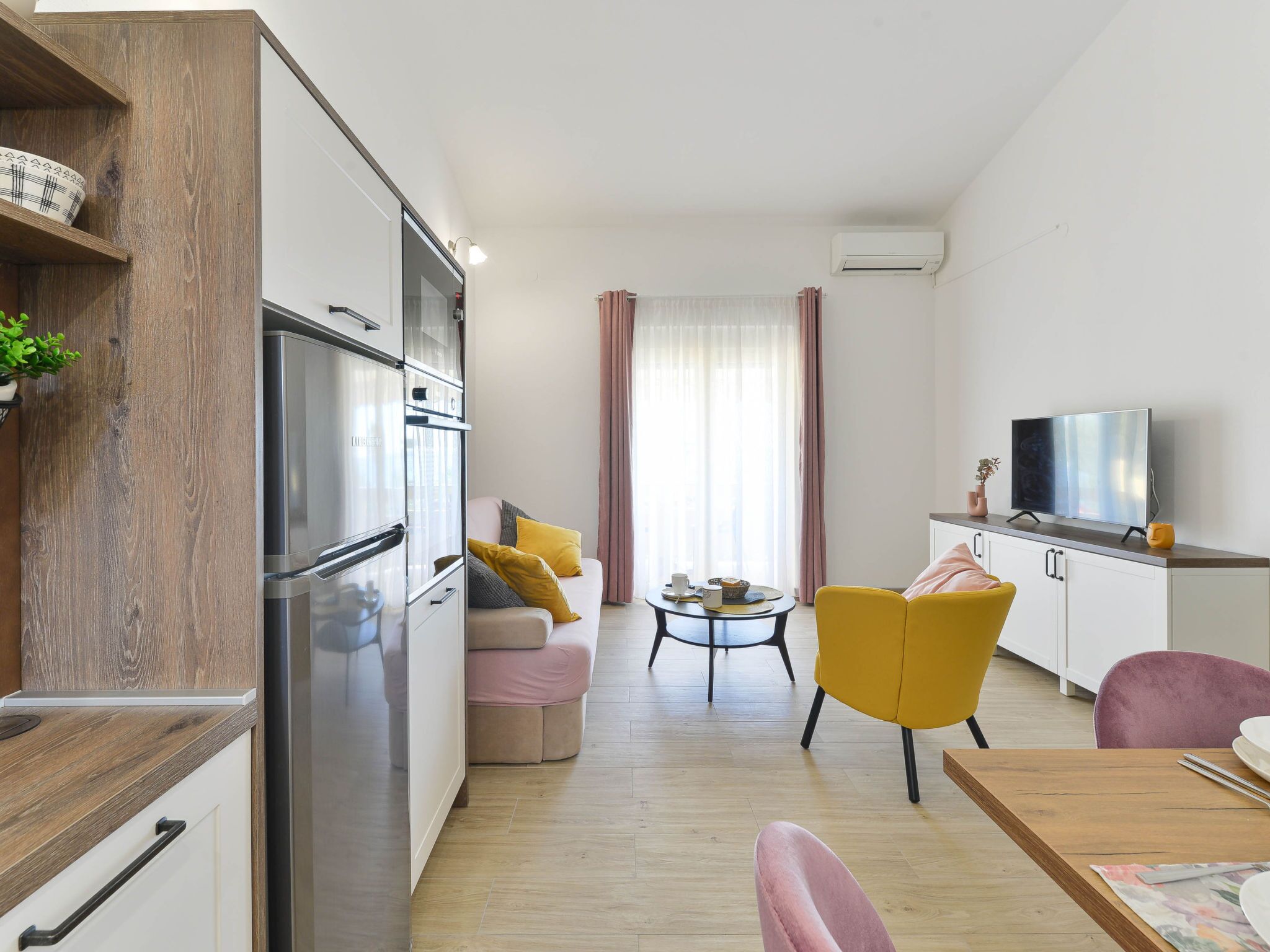 A modern apartment with a kitchen, living area, and dining space.