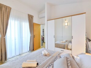 A hotel room with a bed, a wardrobe, and a bathroom visible through an open door. - Holiday Apartment Inga Blue with exit to the beach by Interhome (Vir)
