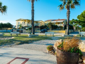 A residential area with two-story houses, a paved driveway, and a parking area. - Apartment  by Interhome (Vir)