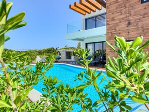 A modern two-story building with a swimming pool, outdoor seating, and lush greenery. - Beautiful villa Tamaria with heated pool by Interhome (Nin)
