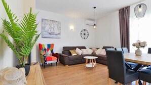 A modern living room with a sofa, a coffee table, and a dining area with a table and chairs. - Vacation home  by Interhome (Nin)