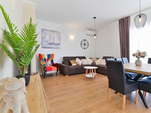 Ein stilvolles Wohnzimmer mit Sofa, Couchtisch und Essbereich mit Tisch und Stühlen.