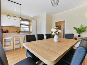 A modern dining area with a wooden table, black chairs, and a vase of flowers. - Villa First Hill with heated pool by Interhome (Nin)