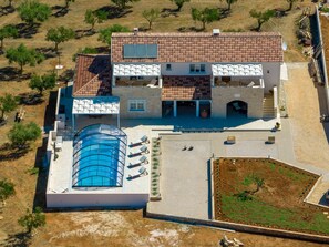 Ein zweistöckiges Gebäude mit Pool, Außenbereich und Garten.