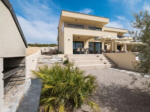 A modern two-story house with a patio area featuring outdoor furniture and umbrellas. - Villa Novue with pool by Interhome (Rovanjska)