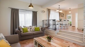 Un salon moderne comprenant un canapé, une table basse et un coin repas avec des chaises et une table.