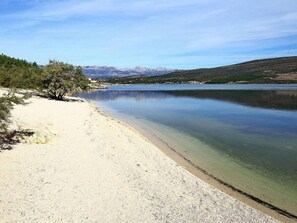 A calm lake with a sandy beach and a tree on the left. - Beachfront villa Noa with heated pool by Interhome (Pridraga)