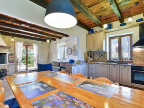 A spacious kitchen with a wooden table, cabinets, and a large window. - Villa Toscana Sole with pool by Interhome (Bokordici)
