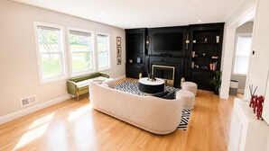 A living room with a sofa, a coffee table, a fireplace, a TV, and a bookshelf. - Welcome to Seven Oaks:Your Home Away From Home (City of Orange)