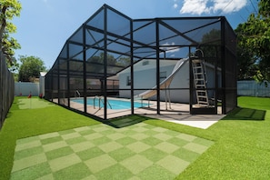 Eine transparente Konstruktion mit Schwimmbecken, Rutsche und Leiter.