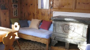 A wooden room with a bed, a stone chest, and a table. - Casa Alpina und Fop Maiensäss, Waltensburg, (Waltensburg/Vuorz), 58011A by Interhome (Surselva)