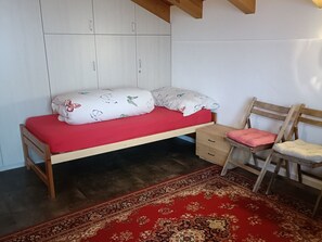A bedroom with a bed, a chair, a desk, and a wardrobe. - Bauernhof Cathomas, Brigels, (Breil/Brigels), 65008B by Interhome (Breil/Brigels)