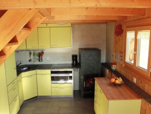 Een koelkast, een oven, kookgerei, borden en bestek