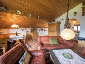 A cozy room with a wooden ceiling, a dining table, a sofa, and a kitchen area. - Casa Panorama Lutz, Brigels, (Breil/Brigels), 65061B by Interhome (Breil/Brigels)