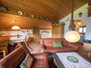 A cozy interior with wooden beams, a leather sofa, a dining table, and a hanging light fixture. - Casa Panorama Lutz, Brigels, (Breil/Brigels), 65061B by Interhome (Breil/Brigels)