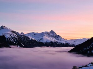 A mountainous landscape with snow-covered peaks and a valley below.