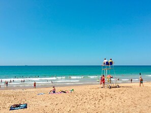 A beach with lifeguards on a tower, people swimming, and a clear blue sky. - Maisonnabe by Interhome (Ondres)