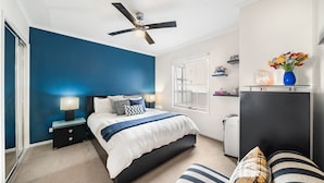 A bedroom with a bed, bedside tables, a ceiling fan, a window, and a dresser. - Light-filled, spacious 2 bdrm Prahran apartment with free parking. (Prahran)