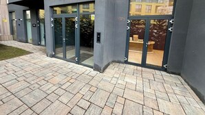 A modern building with a glass entrance, a visible sign with 'SP2', and a paved entrance area.