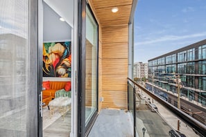 Un edificio moderno con grandes ventanales, un muro interior de madera y vista a la calle.