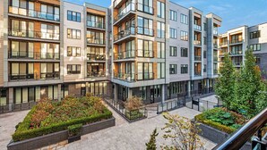 A modern multi-story residential building with balconies, large windows, and a landscaped courtyard. - Chic 1BD Sleeps 2 Near Independence Hall Philly (Philadelphia)