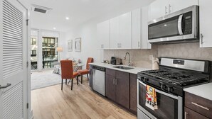 A modern kitchen with a built-in microwave, stove, and dishwasher. - Chic 1BD Sleeps 2 Near Independence Hall Philly (Philadelphia)