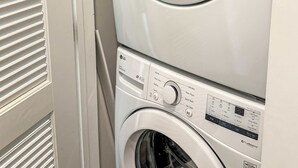 Una lavadora y secadora apiladas, con un panel de control y una puerta.