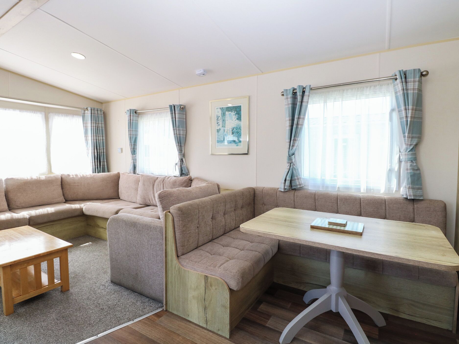 A cozy RV interior with a sofa, a small table, and a dining area.
