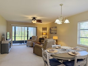 A dining area with a round table, chairs, and a ceiling fan. - Fiddler’s Green 2BR Getaway (Englewood)