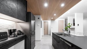 A modern kitchen with a built-in coffee maker, a refrigerator, and a dishwasher. - THE POLARIS (Sapporo)