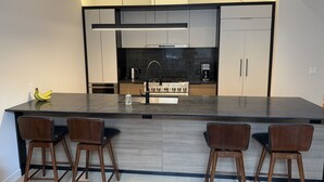 A modern kitchen with a central island, bar stools, and stainless steel appliances. - 2Bed 2.5Bath Pet Friendly Townhouse Downtown Halifax (Halifax)