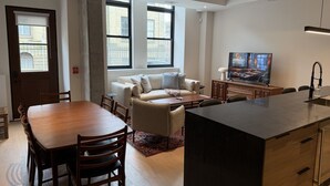 A modern kitchen with a dining area, a sofa, and a TV. - 2Bed 2.5Bath Pet Friendly Townhouse Downtown Halifax (Halifax)