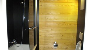 A bathroom with a bathtub, toilet, and wooden wall. - Bevernage, (Splügen), by Interhome (Splügen)