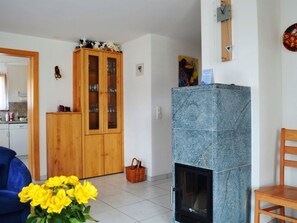 Ein Wohnzimmer mit einem Holzkabinett, einem Kamin und einem Essbereich mit einem Stuhl.