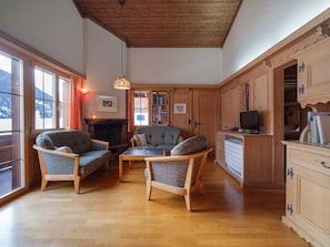A cozy living room with wooden furniture, a fireplace, and a view of the outdoors. - Tingalina Reichlin, (Sedrun), 122.01/.02 by Interhome (Sedrun)