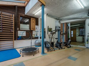 A gym with exercise equipment, a trampoline, and a wooden climbing wall. - Tingalina Reichlin, (Sedrun), 122.01/.02 by Interhome (Sedrun)